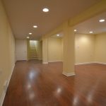 Large basement with white door and stairs