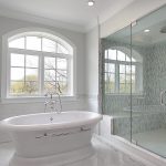 White bathroom with tub and large glass shower