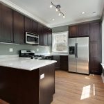 Kitchen with dark brown cabinets and marble counters