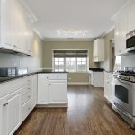 Kitchen with white cabinets and marble counters