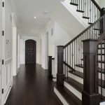 White hallway with dark brown stairs