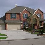 large brick house with concrete driveway